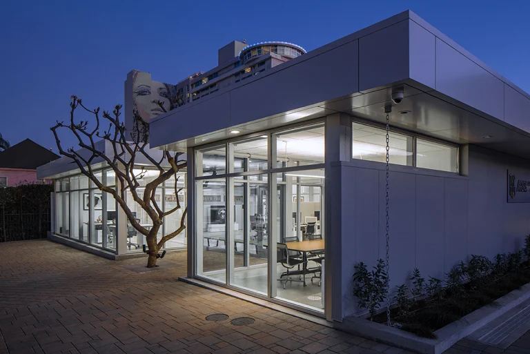 los angeles hollywood arri education center modern sustainable prefabricated steel frame bluesky building systems insulated metal panel office exterior entry built around plumeria tree night copy 1 768x513